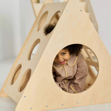 Mädchen spielt und versteckt sich im Montessori-Kletterdreieck
