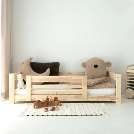 Kinderbett im Kinderzimmer mit hellem Teppich und Montessori-Spielzeug Kinderbett im Kinderzimmer mit hellem Teppich und Montessori-Spielzeug