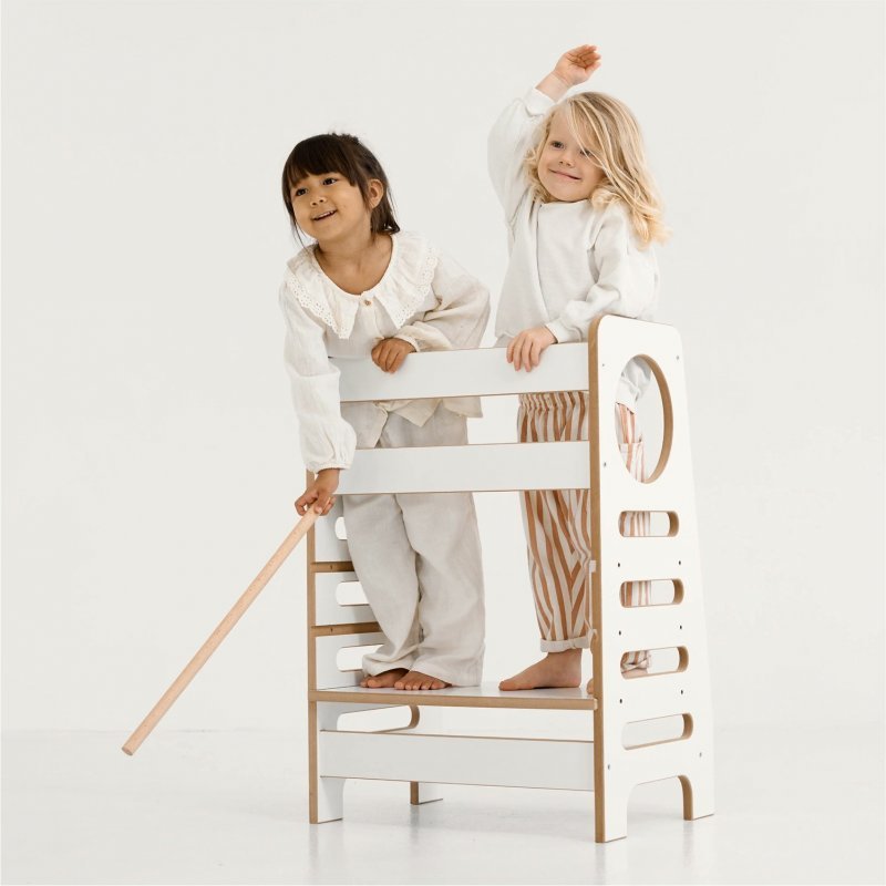 Zwei Kinder auf einem weißen Küchenhelfer