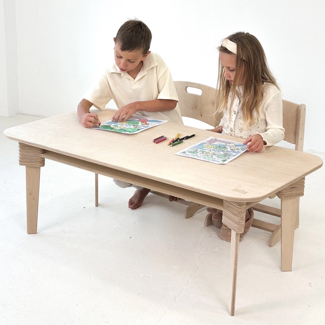 Kinder spielen und malen gemeinsam am stabilen Holztisch