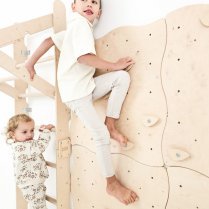 unge an der Kletterwand, daneben Mädchen auf der Sprossenleiter - Spaß im Kinderzimmer unge an der Kletterwand, daneben Mädchen auf der Sprossenleiter - Spaß im Kinderzimmer